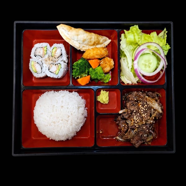 A bento box with sushi, rice, beef, salad, dumplings, and fried chicken with vegetables.